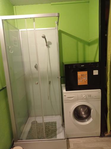 une salle de bain avec une machine à laver et un lave-linge dans l'établissement Studio sur les pistes, à Bagnères-de-Bigorre