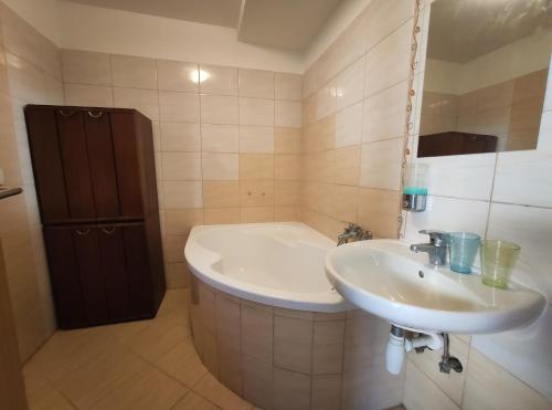 Hulín的住宿－Apartmán Hulín, Chrášťany - bílý，浴室配有盥洗盆和浴缸。