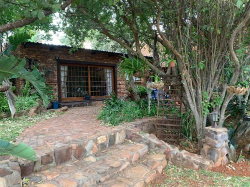 a brick house with a stone path leading to a door at Modjadji Estate Lodge & Spa in Grietjie Nature Reserve