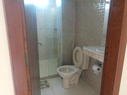 a bathroom with a toilet and a shower and a sink at Ilhéus apto 01 exclusivo in Ilhéus
