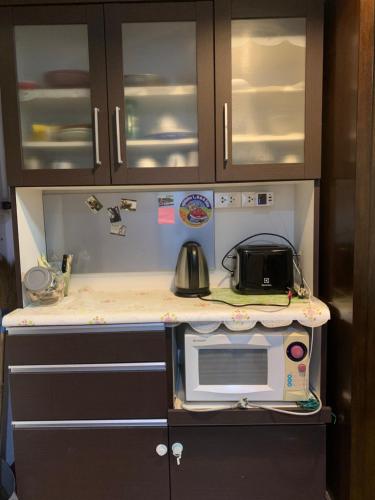 a kitchen with a counter top with a microwave at Kiang Mo Gumpuju in Chiang Mai