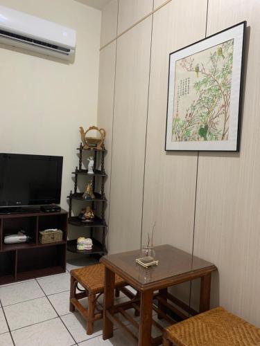 a living room with a table and a tv at Guan Ma Homestay in Miaoli