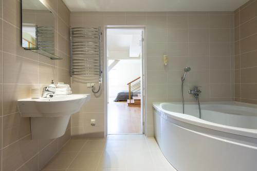 a bathroom with a tub and a sink and a bath tub at Parnidžio Kopa in Nida