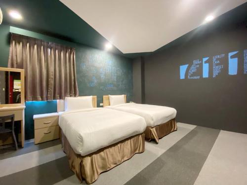 Cette chambre comprend 2 lits et une télévision. dans l'établissement JS Hotel-Gallery Hotel, à Zhongli