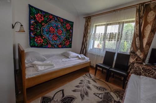 A bed or beds in a room at Pensiunea Denisa
