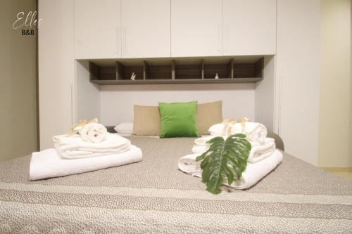 - un lit avec des serviettes et une plante dans l'établissement B&B Elles con parcheggio interno, à Barletta
