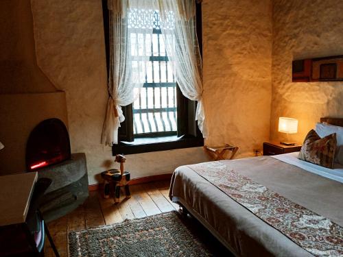 een slaapkamer met een bed en een groot raam bij HOTEL LA POSADA DEL ZAGUÁN in El Retiro