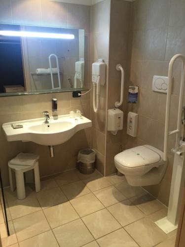 a bathroom with a sink and a toilet and a mirror at Cocca Hotel Royal Thai Spa in Sarnico