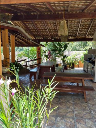 patio con panca in legno e tavolo di Ubatuba Suites Itamambuca a Ubatuba