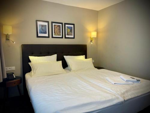a large white bed with two towels on it at Hotel Regina in Ludwigshafen am Rhein