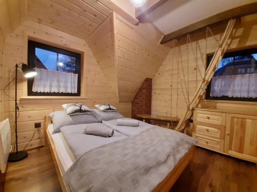 a bedroom with a bed in a wooden room at Domek na brzyzku in Kościelisko