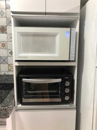 a microwave oven sitting inside of a refrigerator at Blue Marlin Cotovelo - Vista Vale - Reformado in Parnamirim