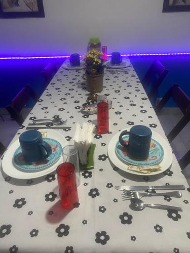 a table with plates and utensils on it at Ipanema Club Hostel in Rio de Janeiro