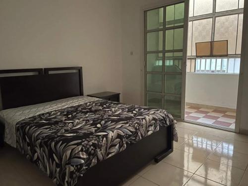 a bedroom with a bed and a large window at Furnished room in a villa in town center. With private bathroom in Al 'Ayn