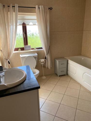 y baño con bañera, aseo y lavamanos. en Gallagh Guest House self catering h18r252 Eircode, en Monaghan