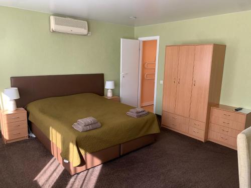 um pequeno quarto com uma cama e uma cómoda em Laisves 30 em Mažeikiai