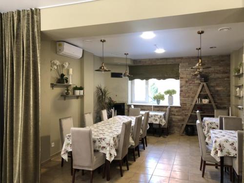 uma sala de jantar com mesas e cadeiras e uma parede de tijolos em Laisves 30 em Mažeikiai