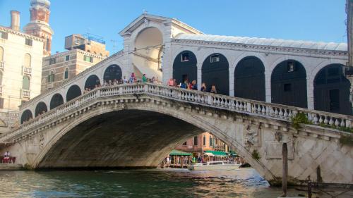 un ponte su un fiume con gente che ci cammina sopra di come a casa tua dietro piazza San Marco a Venezia
