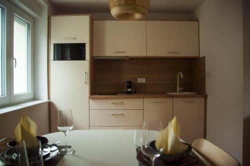 Chang Thai apartments في ليوبليانا: مطبخ مع طاولة مع كؤوس للنبيذ عليه