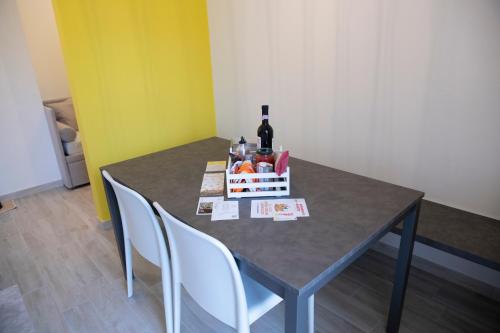 a table with a bottle of wine and a basket of fruit at Marigold Residence in Roseto degli Abruzzi