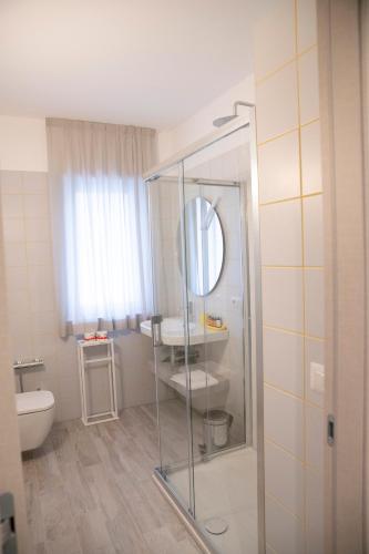 a bathroom with a sink and a toilet and a mirror at Marigold Residence in Roseto degli Abruzzi