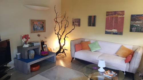 a living room with a couch and a table at Chambre d'hôte Les Jardins Du Forcone in Ajaccio