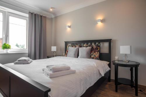 sypialnia z dużym łóżkiem z dwoma ręcznikami w obiekcie Apartamenty Rynek 27 w mieście Prószków