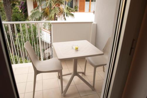 a small white table and chairs on a balcony at Marigold Residence in Roseto degli Abruzzi