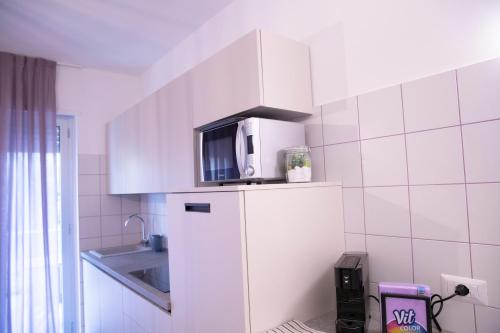 a kitchen with a microwave on top of a refrigerator at Marigold Residence in Roseto degli Abruzzi