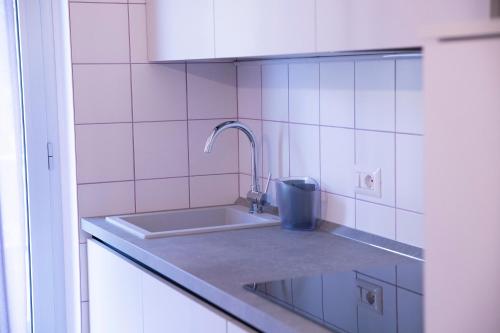 a kitchen with a sink and pink tiles at Marigold Residence in Roseto degli Abruzzi