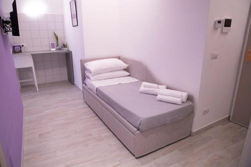 a small room with a bed with towels on it at Marigold Residence in Roseto degli Abruzzi