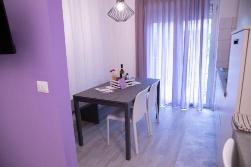 a dining room table with chairs and a table with wine bottles on it at Marigold Residence in Roseto degli Abruzzi