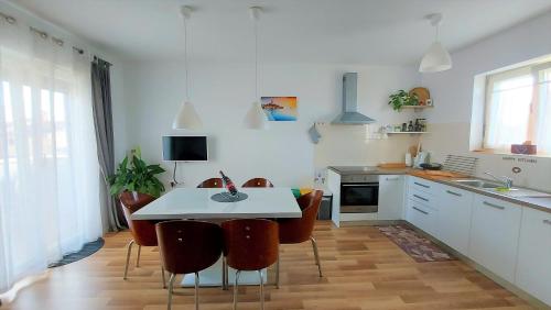 a kitchen with a white table and some chairs at Rooms and Apartments IstraSoley in Bale