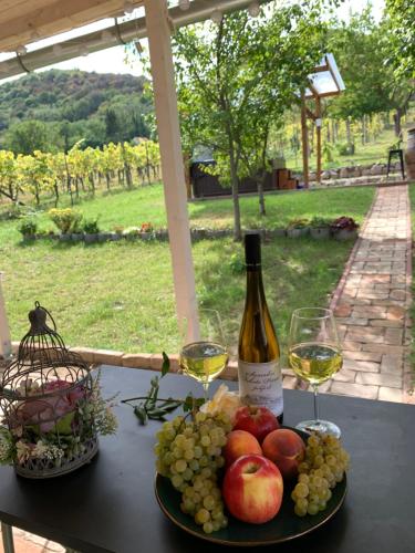 a table with a plate of fruit and wine glasses at Smaragd in Doba