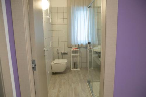 a bathroom with a toilet and a glass shower at Marigold Residence in Roseto degli Abruzzi