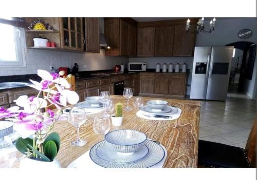 a kitchen with a table with plates and wine glasses at Luxury Villa L'ile Maurice in Pointe aux Cannoniers