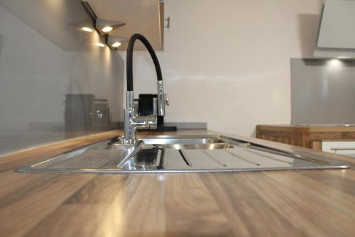 a kitchen sink with a faucet on a wooden floor at Apartment Hanske in Isenbüttel