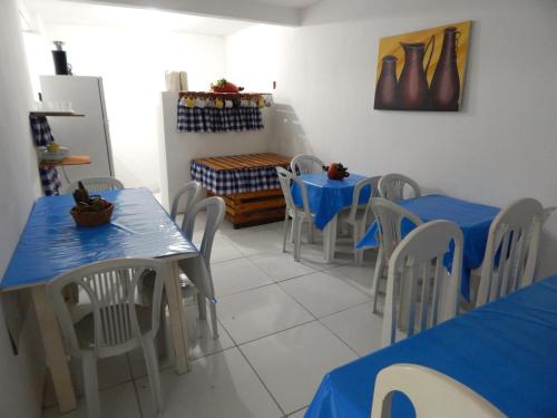 a dining room with blue tables and chairs at Praia Hostel in Maragogi