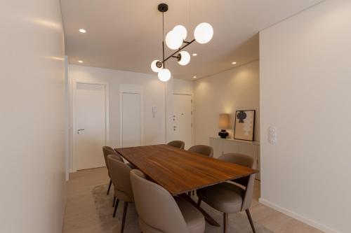 ein Esszimmer mit einem Holztisch und Stühlen in der Unterkunft ORM Antero Apartment in Porto