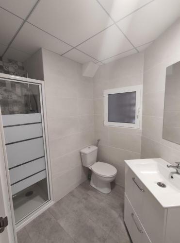 a white bathroom with a toilet and a sink at Albir cosy apartment in Albir