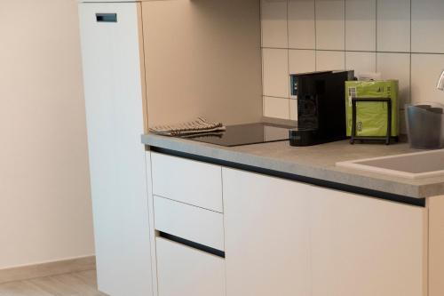 a kitchen with white cabinets and a counter top at Marigold Residence in Roseto degli Abruzzi