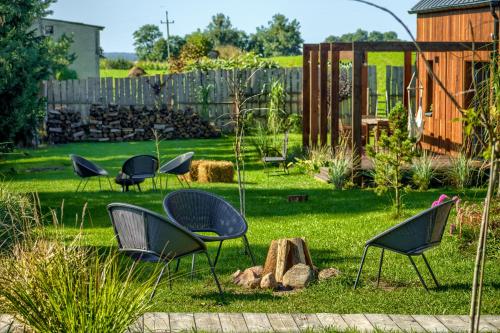 a group of chairs sitting in a yard at Pod Mazurskim Niebem boho in Piecki