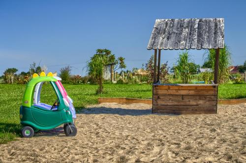 a small car parked in the sand next to a playground at Pod Mazurskim Niebem boho in Piecki