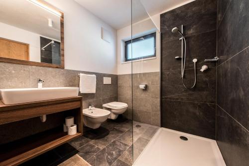 a bathroom with a sink and a toilet and a shower at Chalet Kristall - Dolomites Garden Chalet in Falzes