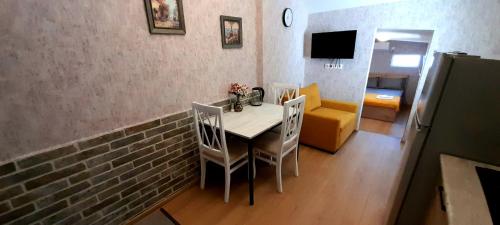 ein Esszimmer mit einem Tisch, Stühlen und einer Ziegelwand in der Unterkunft Yellow Apartment in Tbilisi City