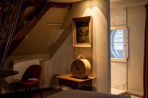 a bedroom with a staircase with a mirror and a chair at B&B l'histoire de l'éclair in Bruges