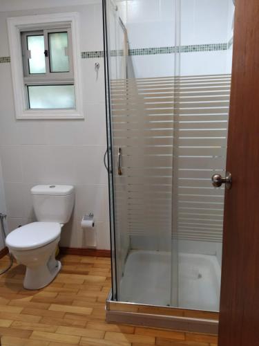 ein Badezimmer mit Toilette und Glasdusche in der Unterkunft Cabaña I Punta Negra in Piriápolis