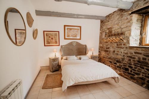 een slaapkamer met een bed en een bakstenen muur bij moulin de kerdavid in Pluvigner