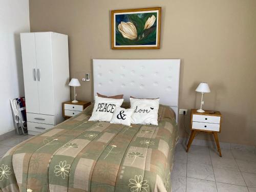 a bedroom with a bed with two night stands and two lamps at Lo de Nora, ColónER in Colón