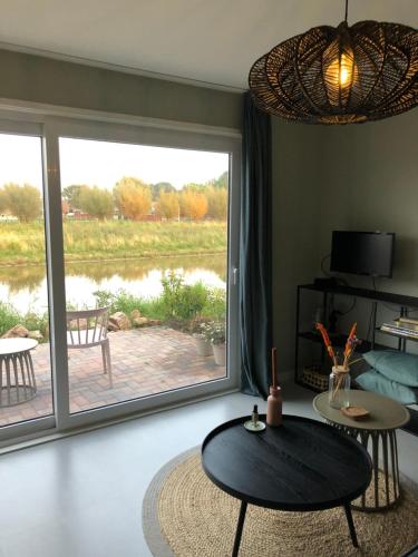 a living room with a large sliding glass door at B&B Snurk Stiens, fijn verblijf aan open vaarwater in Stiens